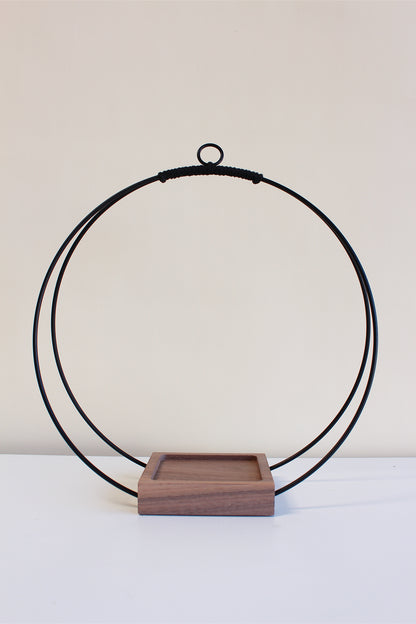 large circular hanging planter with matte black rings and walnut wood base